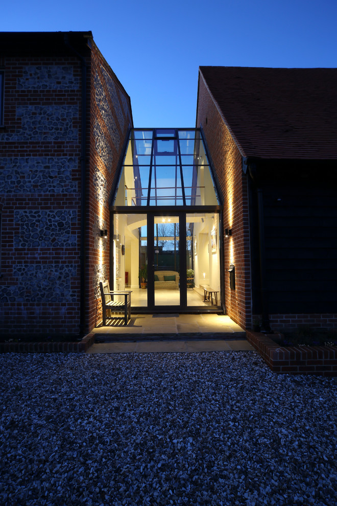 Photo of a red contemporary two floor brick house exterior in Other with a pitched roof.