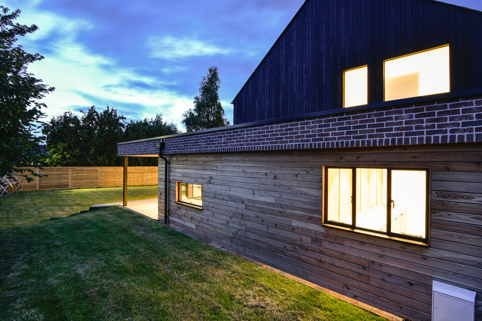 Cette image montre une façade de maison design en bois à un étage.
