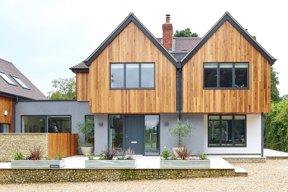 Cette image montre une grande façade de maison design en bois à un étage.