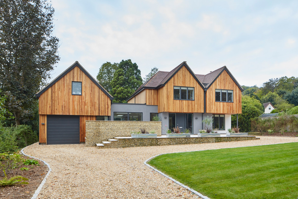 Photo of a large contemporary two floor detached house in Berkshire with wood cladding.