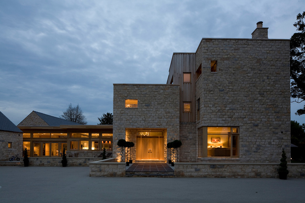 Idee per la facciata di una casa contemporanea a tre piani con rivestimento in pietra e tetto piano