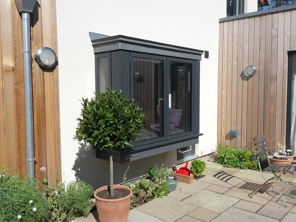 Imagen de fachada de casa gris contemporánea de tamaño medio de dos plantas con revestimiento de madera