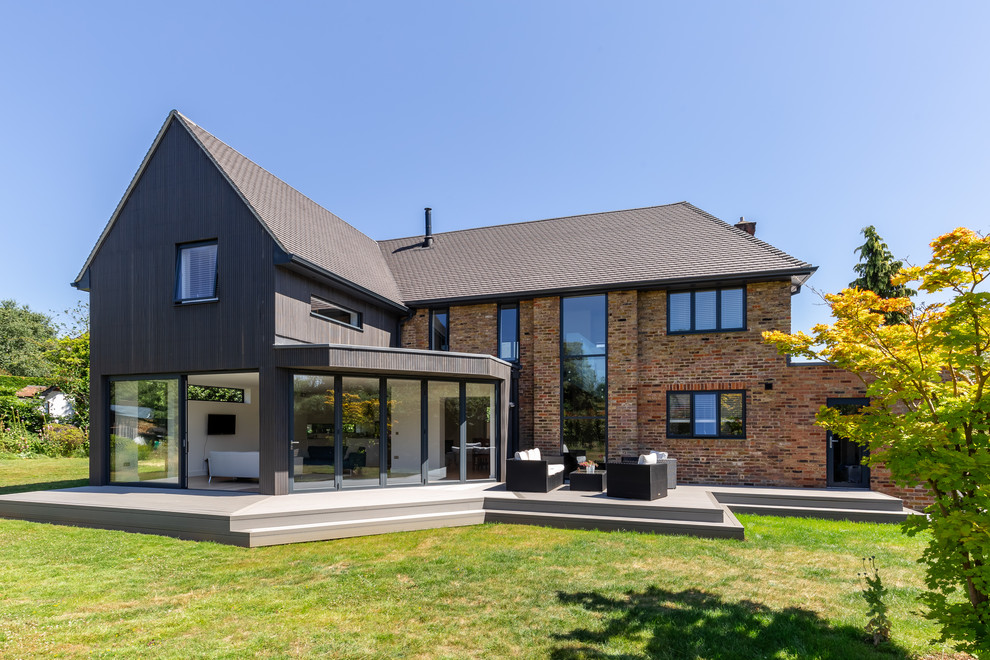 Aménagement d'une grande façade de maison beige contemporaine en brique à un étage avec un toit à deux pans.