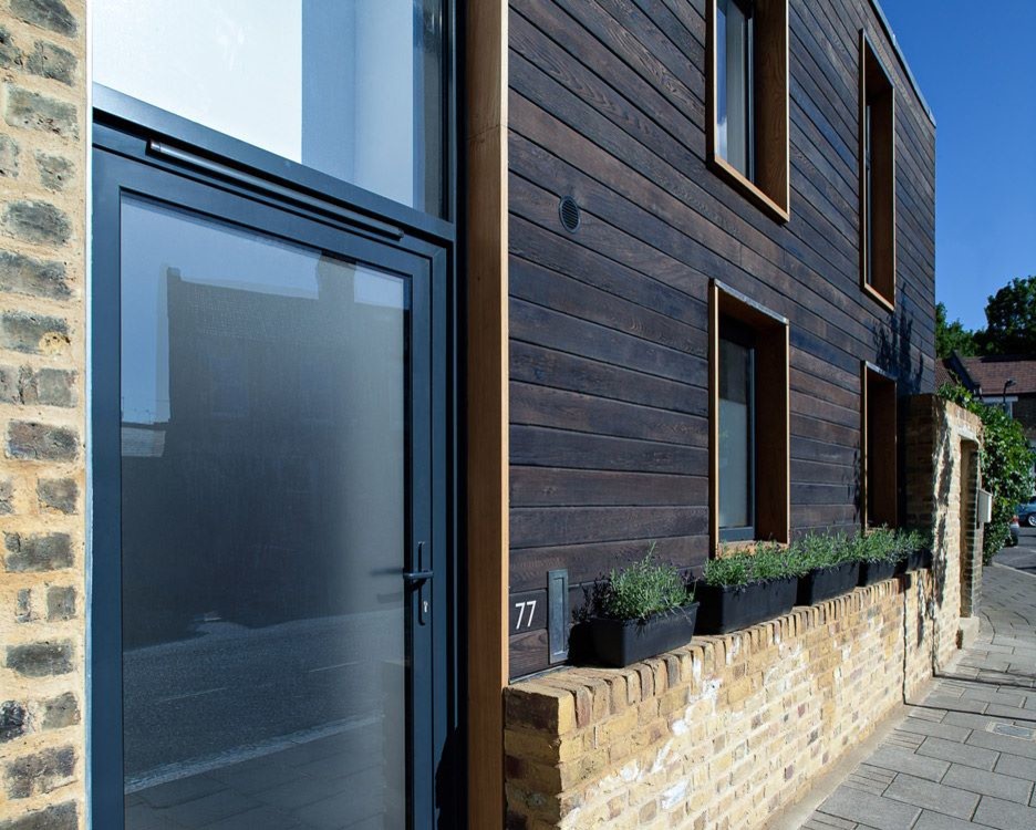 Design ideas for a medium sized and black contemporary two floor house exterior in Buckinghamshire with wood cladding.