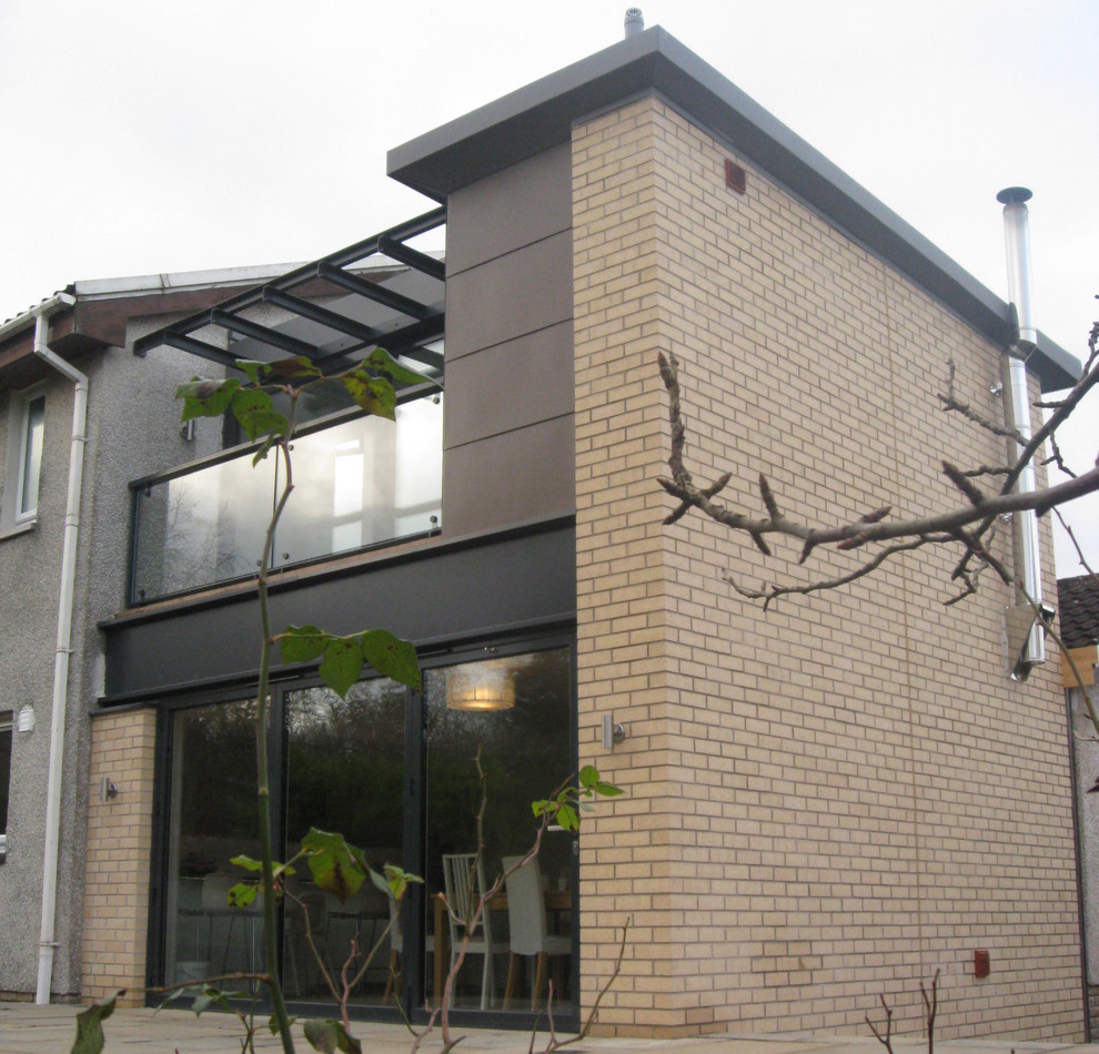 Foto della villa marrone contemporanea a due piani di medie dimensioni con rivestimento in mattoni, tetto piano e copertura in metallo o lamiera