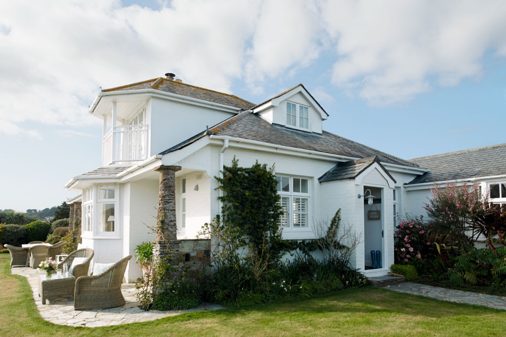 Zweistöckiges Maritimes Einfamilienhaus mit weißer Fassadenfarbe, Walmdach und Schindeldach in Sonstige