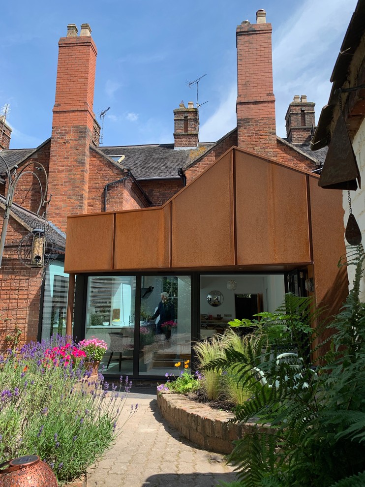 Kleines, Einstöckiges Modernes Reihenhaus mit Metallfassade, brauner Fassadenfarbe, Satteldach und Misch-Dachdeckung in West Midlands