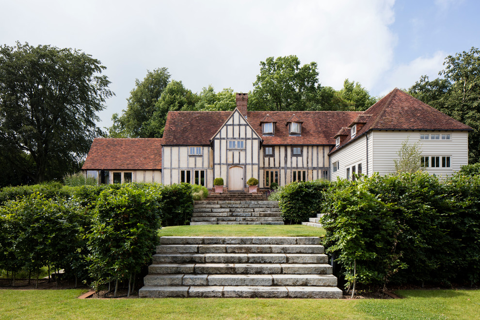 Foto della villa ampia beige classica a tre piani con rivestimenti misti e tetto a padiglione