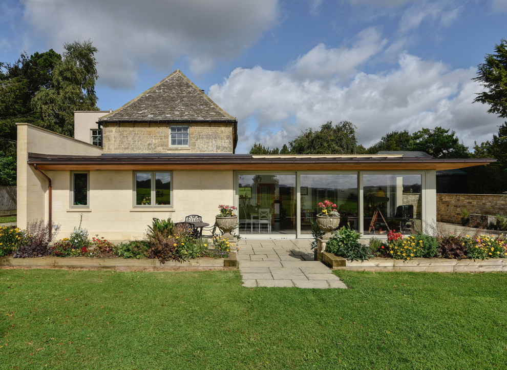 Example of a transitional two-story stone house exterior design in Gloucestershire