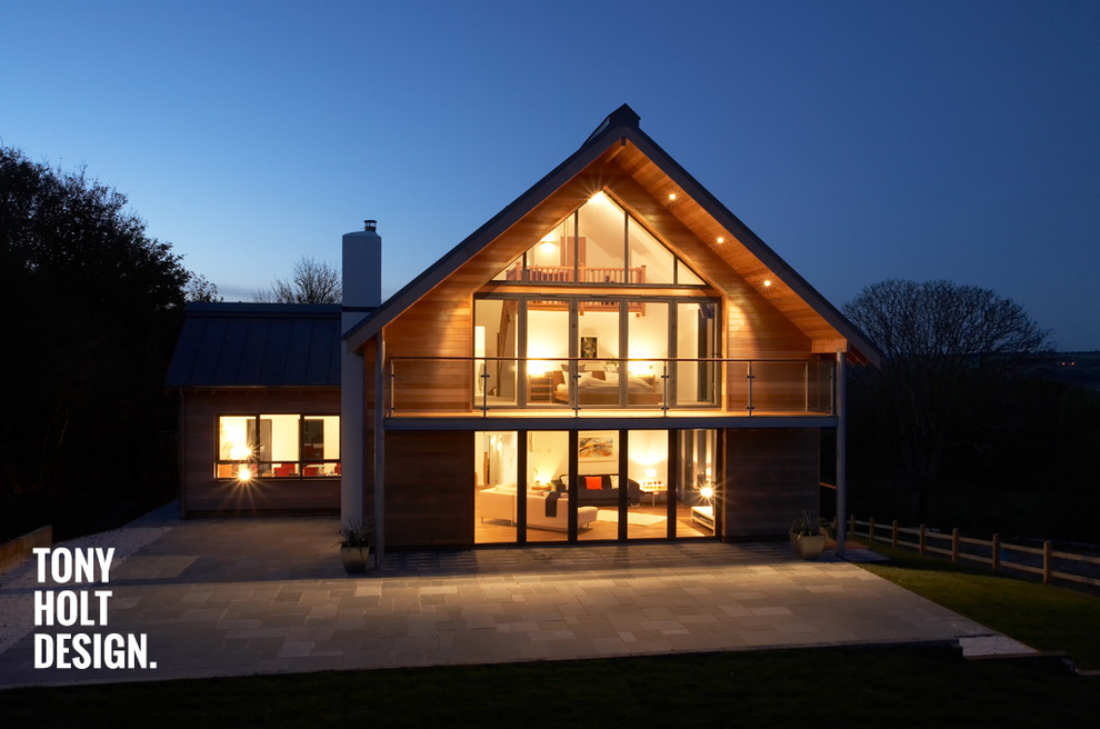 Diseño de fachada marrón moderna grande a niveles con revestimiento de madera y tejado a dos aguas