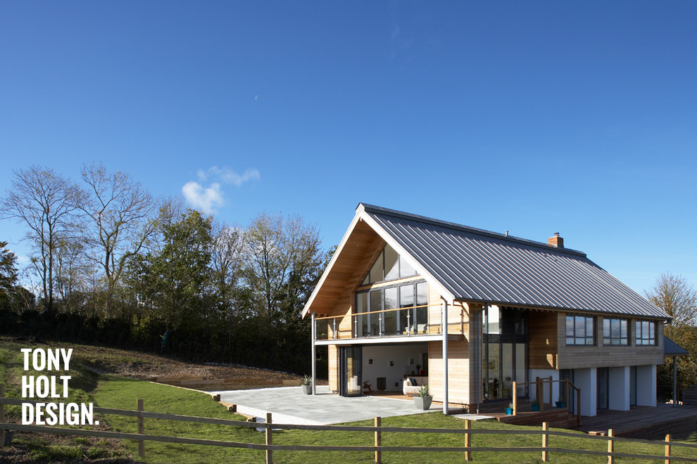 Große Moderne Holzfassade Haus mit brauner Fassadenfarbe und Satteldach in Dorset