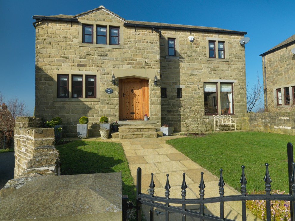 Immagine della facciata di una casa country con rivestimento in pietra