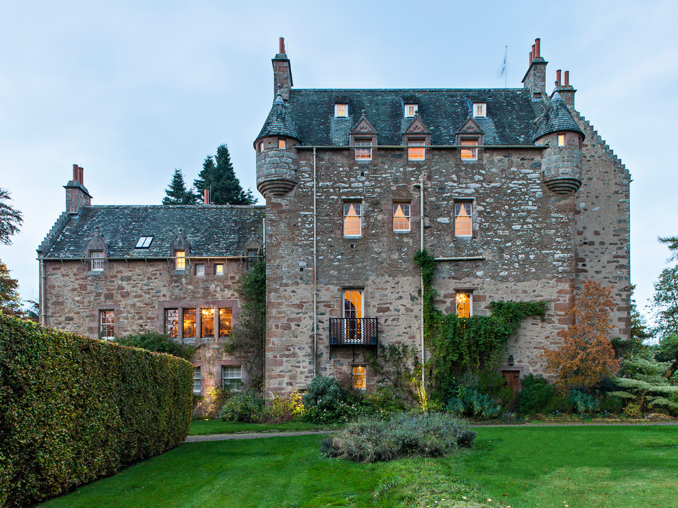 Inspiration for a timeless three-story stone gable roof remodel in London