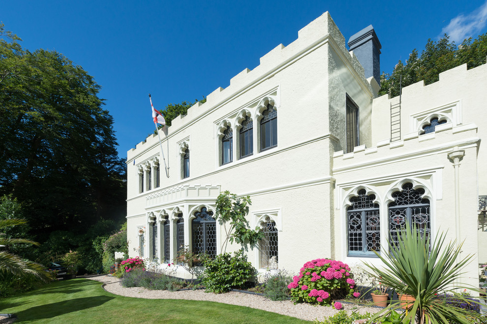 Foto de fachada blanca clásica grande de dos plantas con revestimiento de estuco