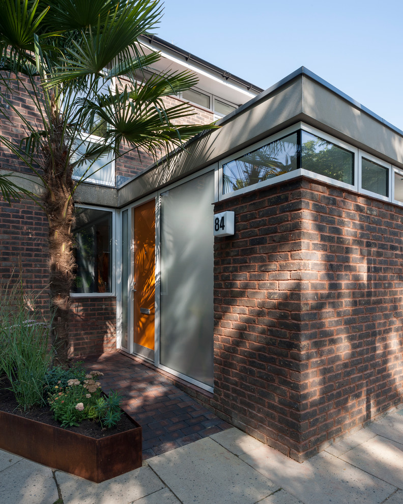 Idee per la facciata di una casa piccola rossa moderna a due piani con rivestimento in mattoni e tetto piano
