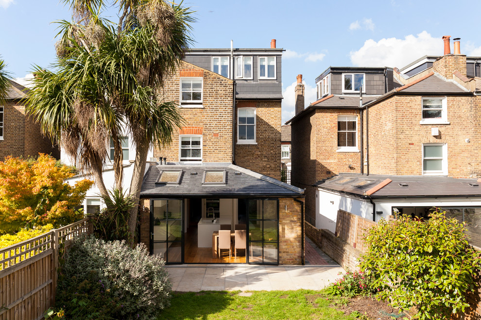 Traditional three-story brick exterior home idea in London