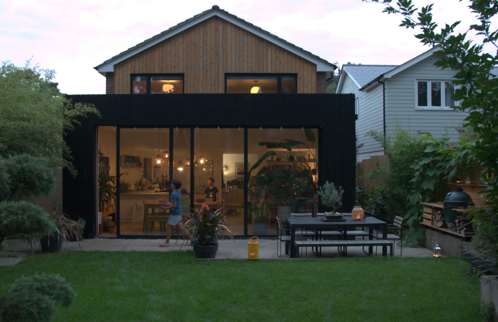 Foto de fachada de casa multicolor y marrón nórdica de tamaño medio de dos plantas con revestimiento de madera, tejado a dos aguas, tejado de teja de barro y panel y listón