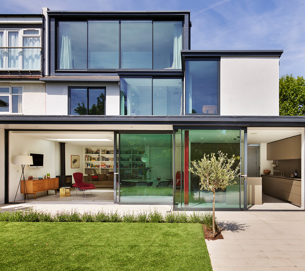 Inspiration for a large and white modern render semi-detached house in Other with three floors and a flat roof.