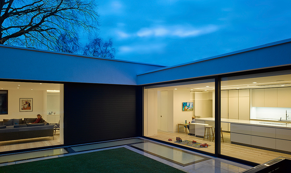 Large and white contemporary bungalow house exterior in London with a flat roof.