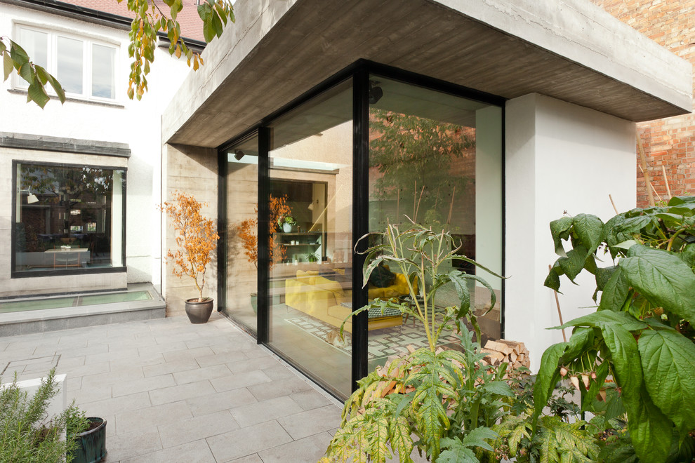 Medium sized and white contemporary concrete house exterior in London with three floors.