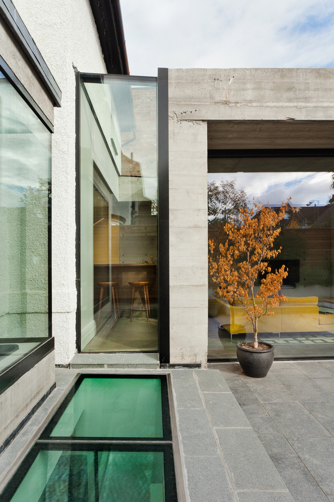 Immagine della facciata di una casa bianca contemporanea a tre piani di medie dimensioni con rivestimento in cemento