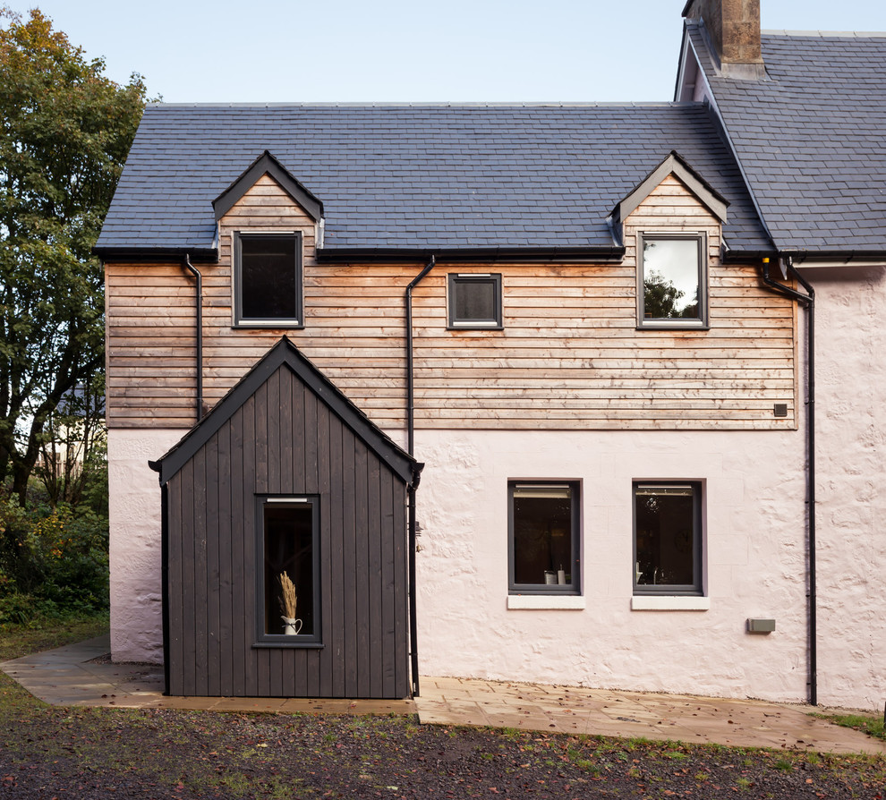 Cette photo montre une grande façade de maison grise chic en bois à un étage avec un toit à deux pans et un toit en tuile.