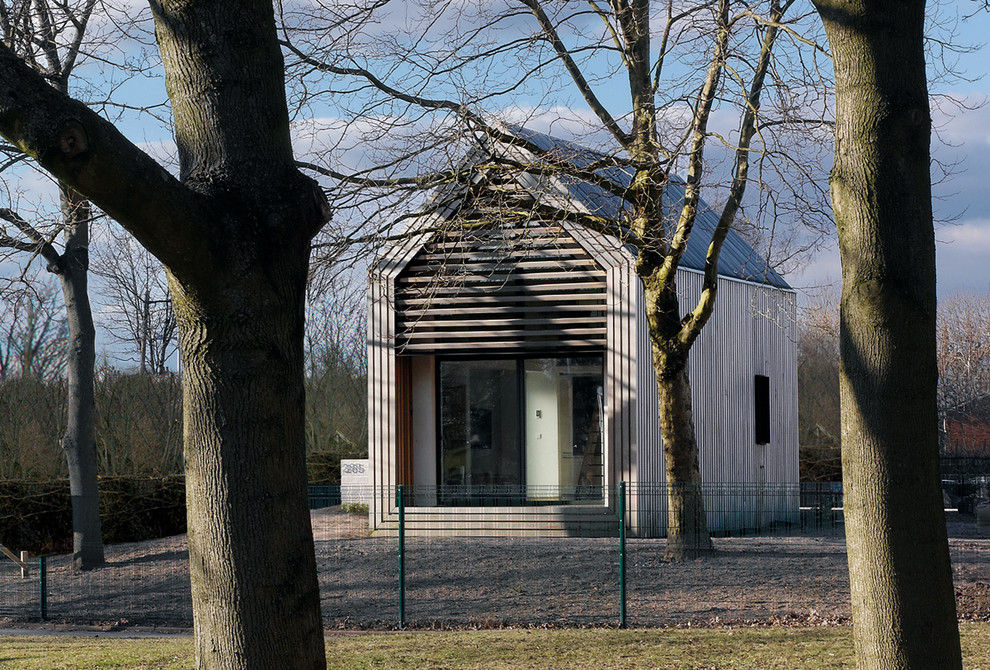 Imagen de fachada marrón actual con revestimiento de madera y tejado a dos aguas