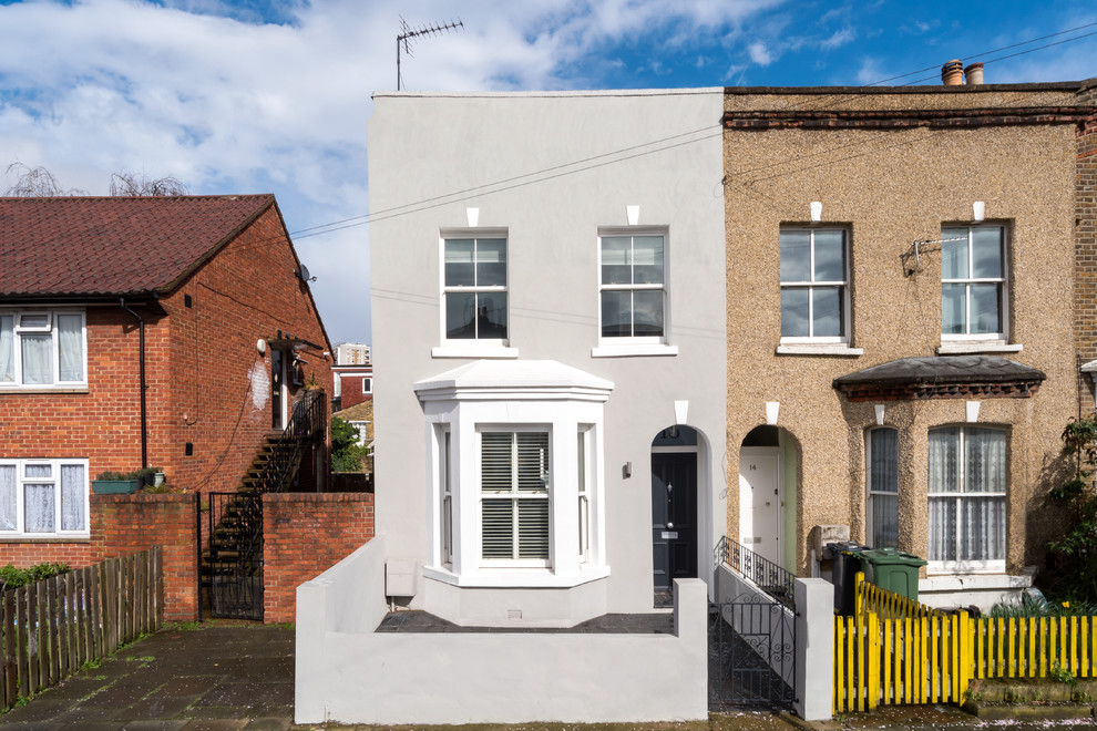 Gey classic two floor render house exterior in London with a flat roof.