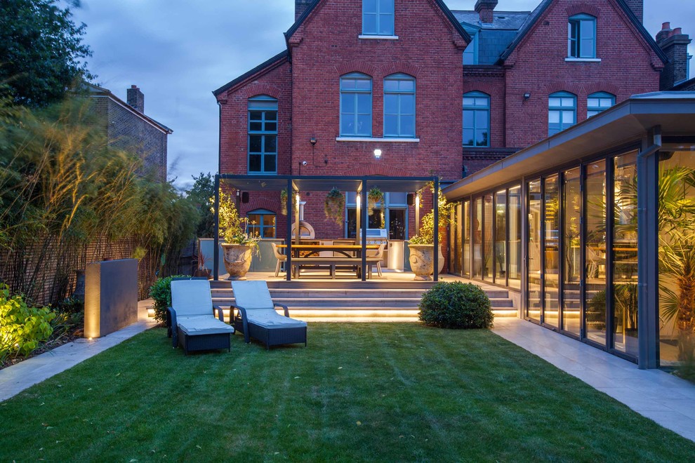 Inspiration for an expansive and red contemporary brick house exterior in Hampshire with three floors and a hip roof.