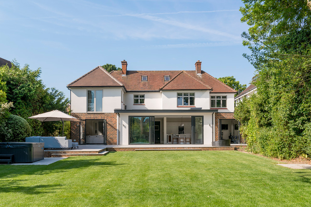 Photo of a large and white traditional detached house in Surrey with three floors, mixed cladding and a tiled roof.