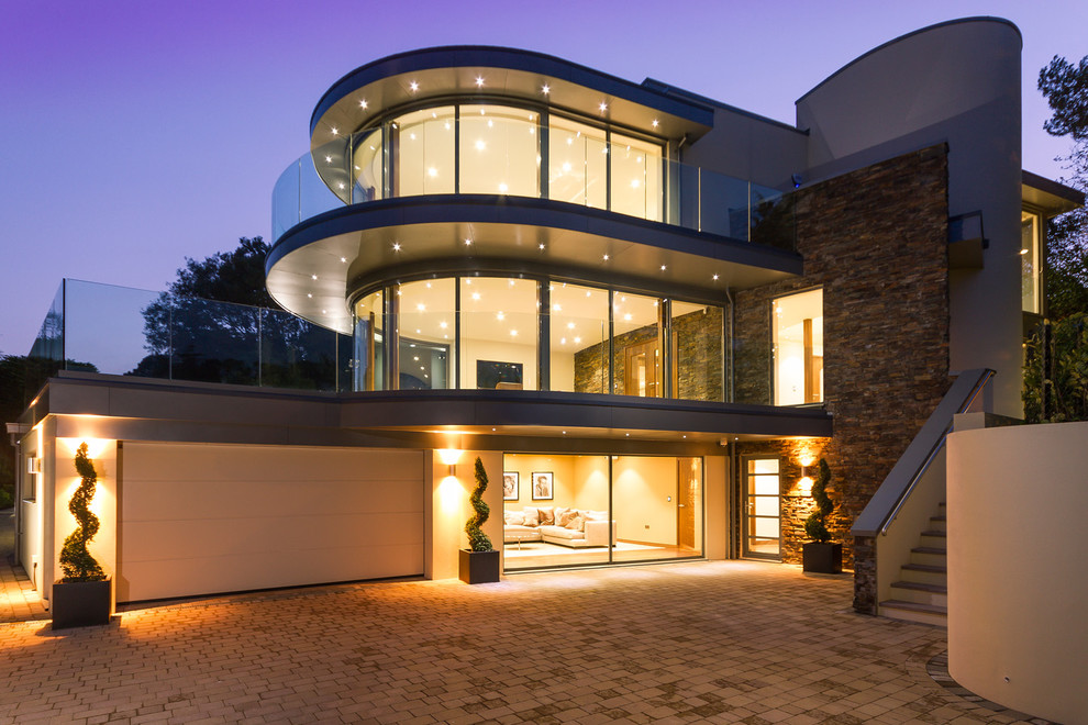 Inspiration for a large modern white three-story stone exterior home remodel in Dorset