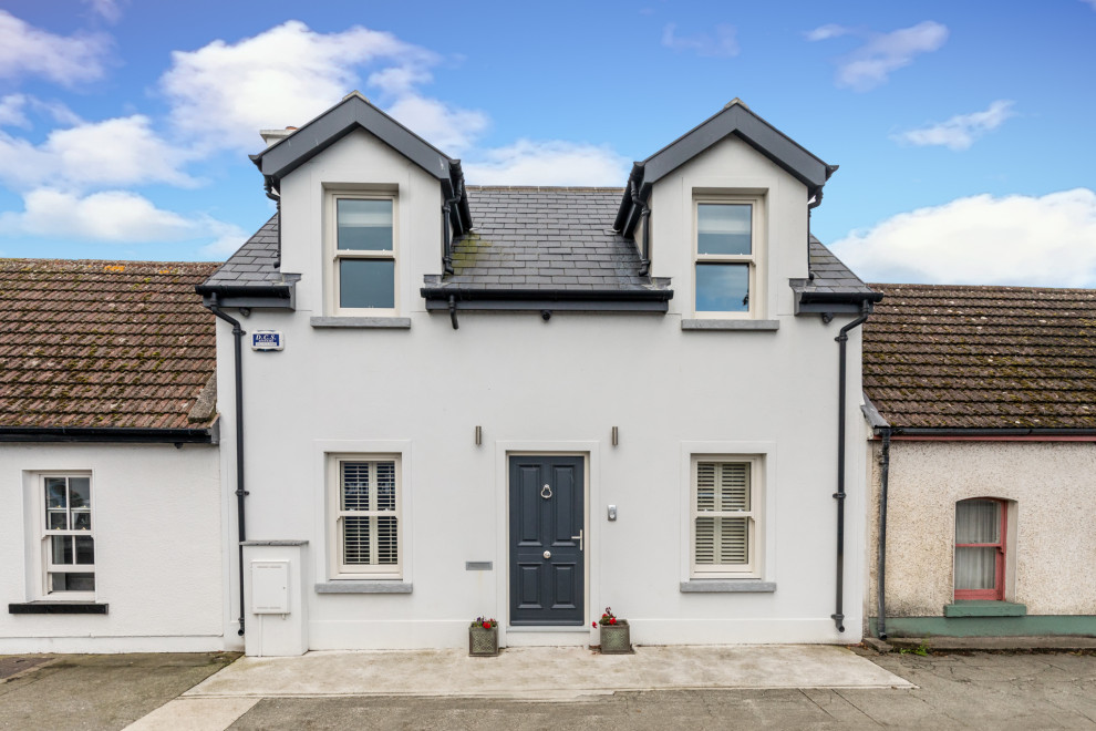Inspiration for a medium sized and white contemporary two floor render house exterior in Dublin with a pitched roof and a tiled roof.