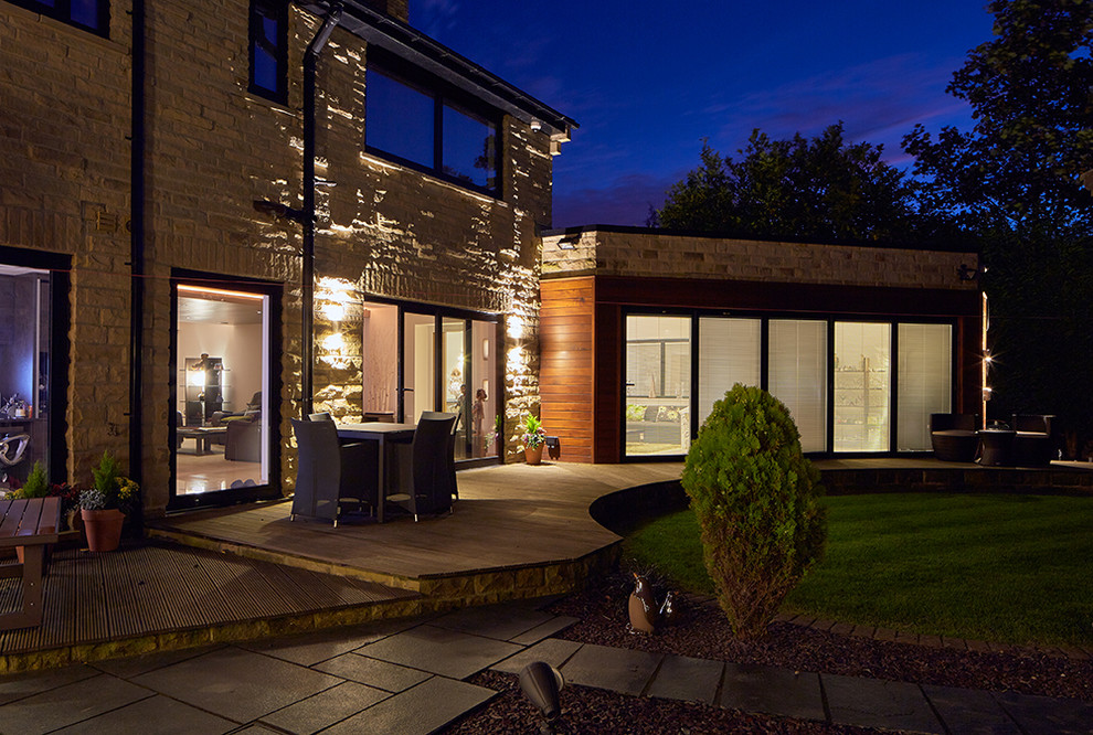 This is an example of a large contemporary two floor house exterior in Other with stone cladding and a pitched roof.