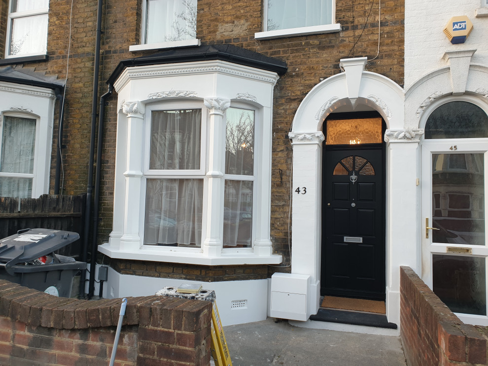 This is an example of a medium sized and multi-coloured traditional two floor painted brick terraced house in London with a pitched roof and a tiled roof.