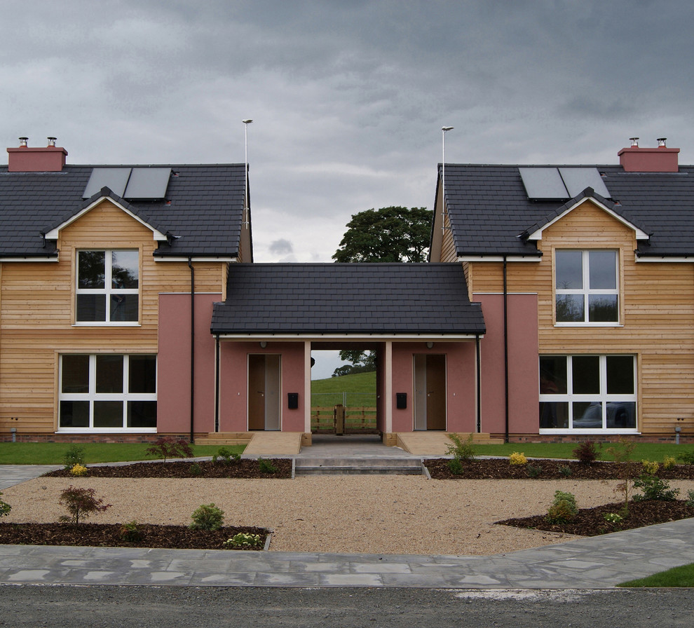 Mittelgroßes, Zweistöckiges Landhaus Haus mit Satteldach, bunter Fassadenfarbe und Ziegeldach in Sonstige