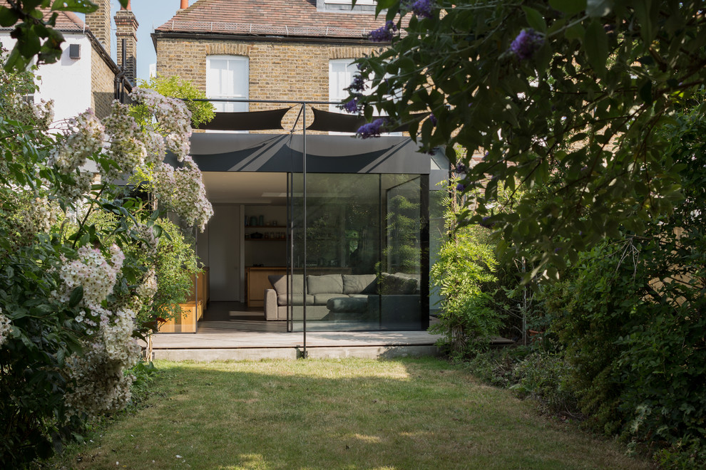 Ispirazione per la facciata di una casa contemporanea con rivestimento in vetro