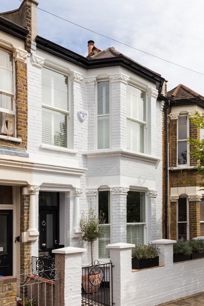 Inspiration for a medium sized and white classic two floor brick house exterior in London with a pitched roof.