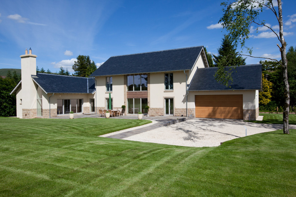 Cette image montre une façade de maison beige design avec un revêtement mixte et un toit à deux pans.