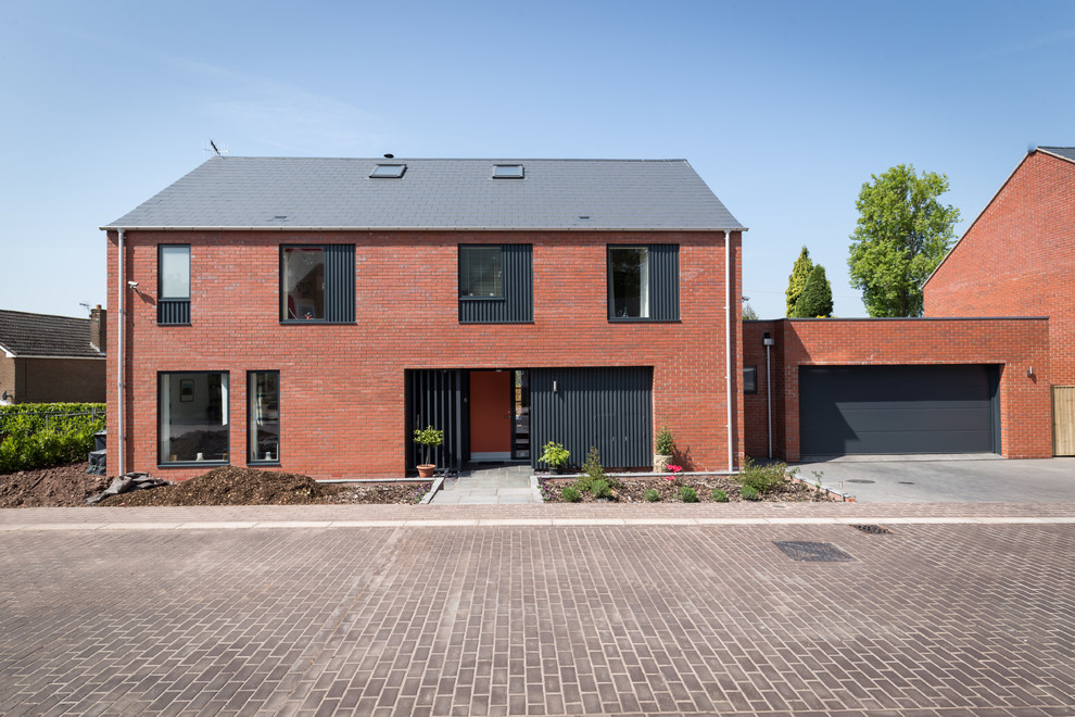 Photo of a medium sized and red modern brick detached house in West Midlands with three floors and a pitched roof.