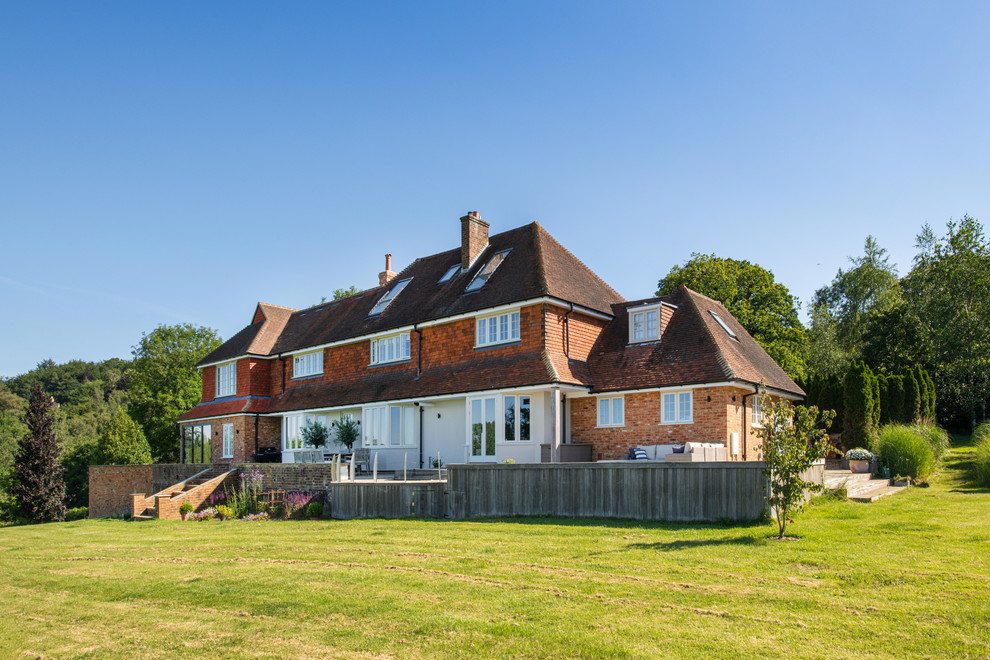 Zweistöckiges Landhausstil Einfamilienhaus mit Mix-Fassade, brauner Fassadenfarbe, Walmdach und Schindeldach in Surrey