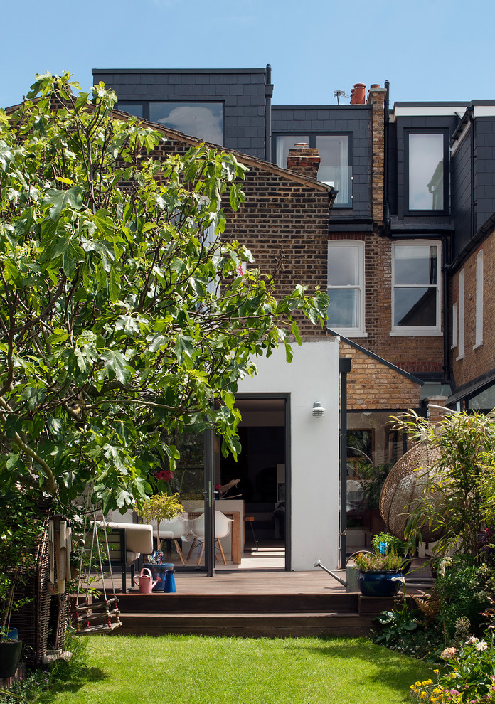 Photo of a brown classic terraced house in London with three floors, mixed cladding, a flat roof and a shingle roof.