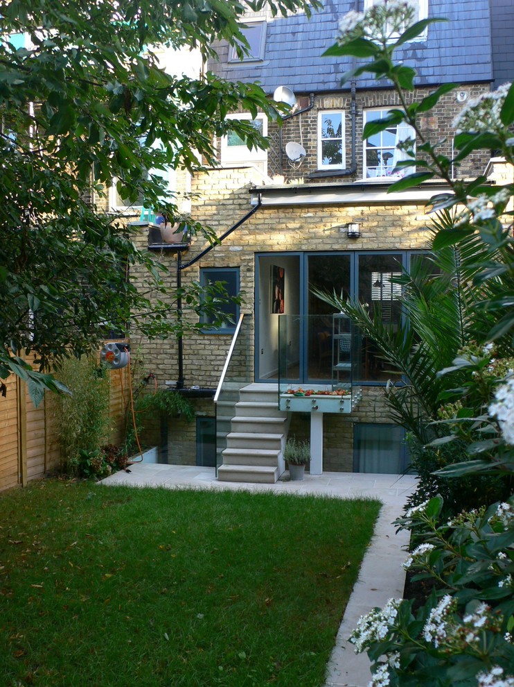 Kleines, Zweistöckiges Modernes Haus mit Backsteinfassade, beiger Fassadenfarbe und Flachdach in Surrey