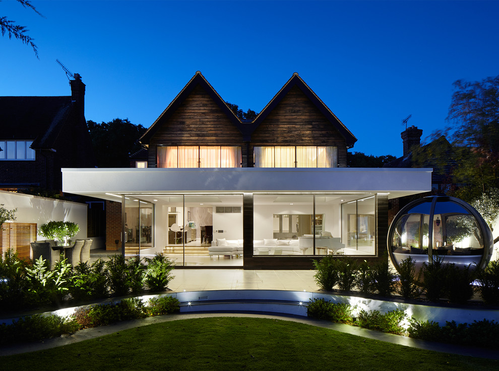 Cette photo montre une façade de maison tendance à un étage avec un revêtement mixte et un toit plat.