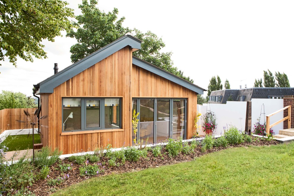 Inspiration for a brown scandi bungalow house exterior in Other with wood cladding and a pitched roof.