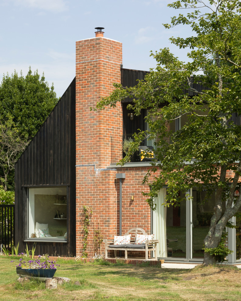 Ejemplo de fachada de casa contemporánea de dos plantas con revestimientos combinados