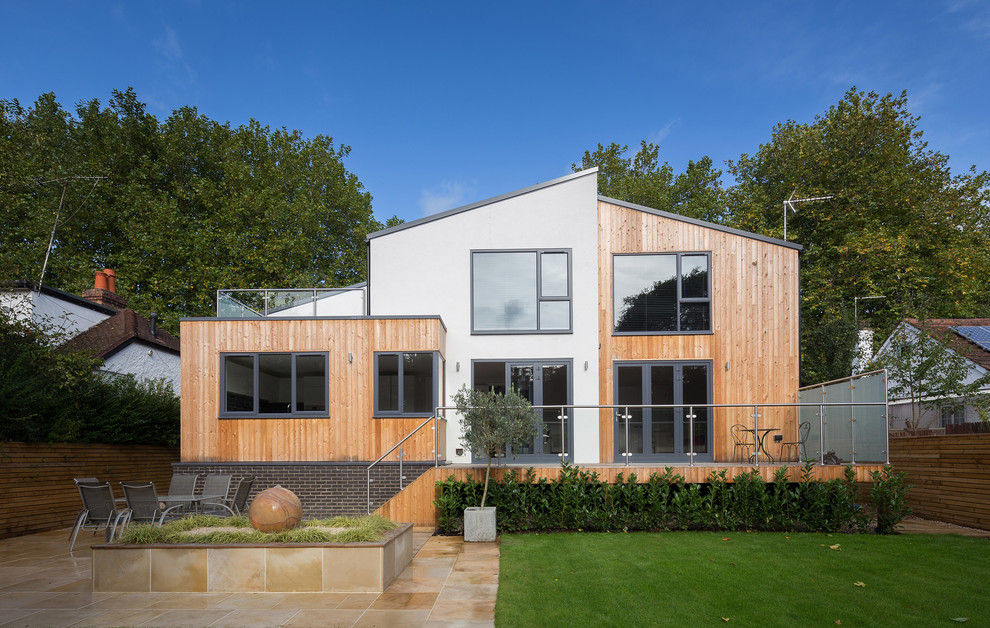 Cette image montre une façade de maison blanche design en bois de taille moyenne et à un étage avec un toit à deux pans.