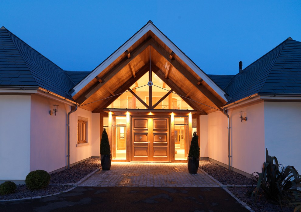 Diseño de fachada beige contemporánea extra grande de tres plantas con revestimiento de estuco y tejado a cuatro aguas