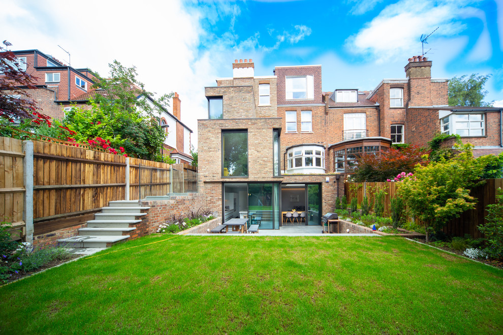 Mid-sized trendy beige three-story brick exterior home photo in London