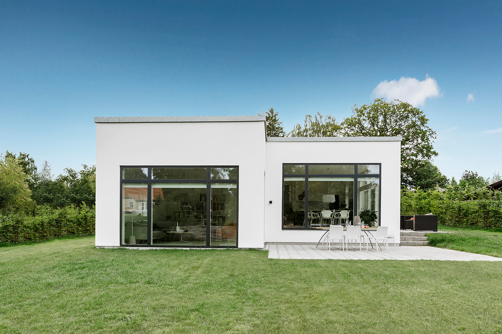 Свежая идея для дизайна: одноэтажный, белый дом в скандинавском стиле с плоской крышей - отличное фото интерьера