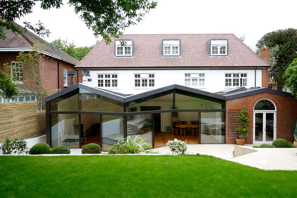 Photo of a large contemporary rear extension in London with mixed cladding and a hip roof.